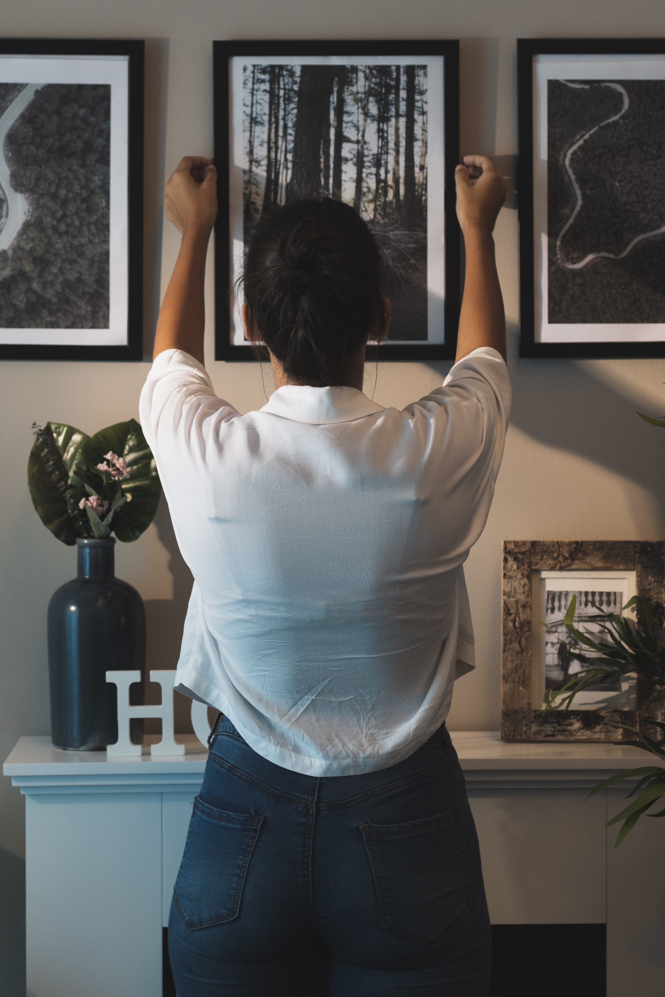 back view woman arranging painting