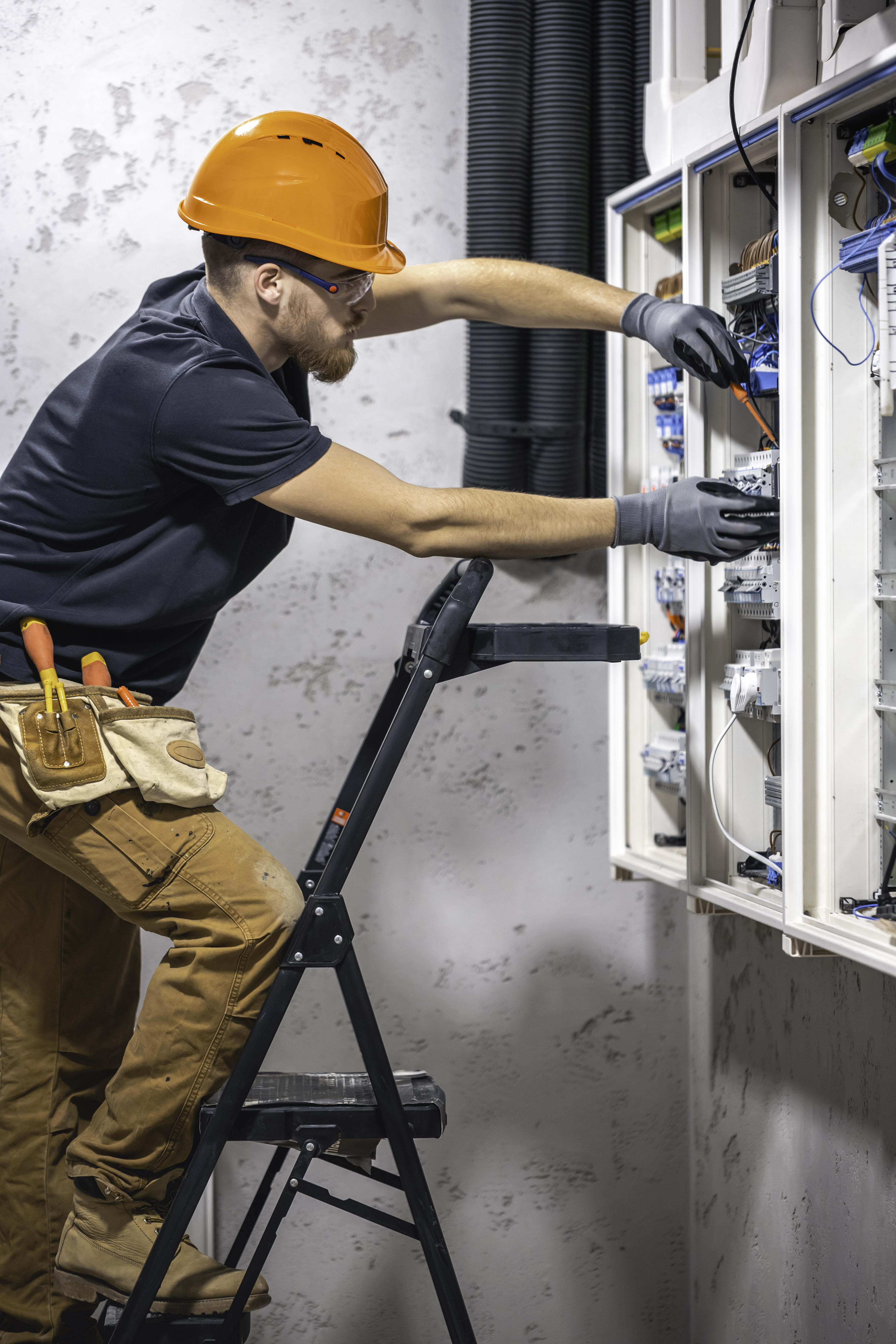 male electrician working in a switchboard with fuses.