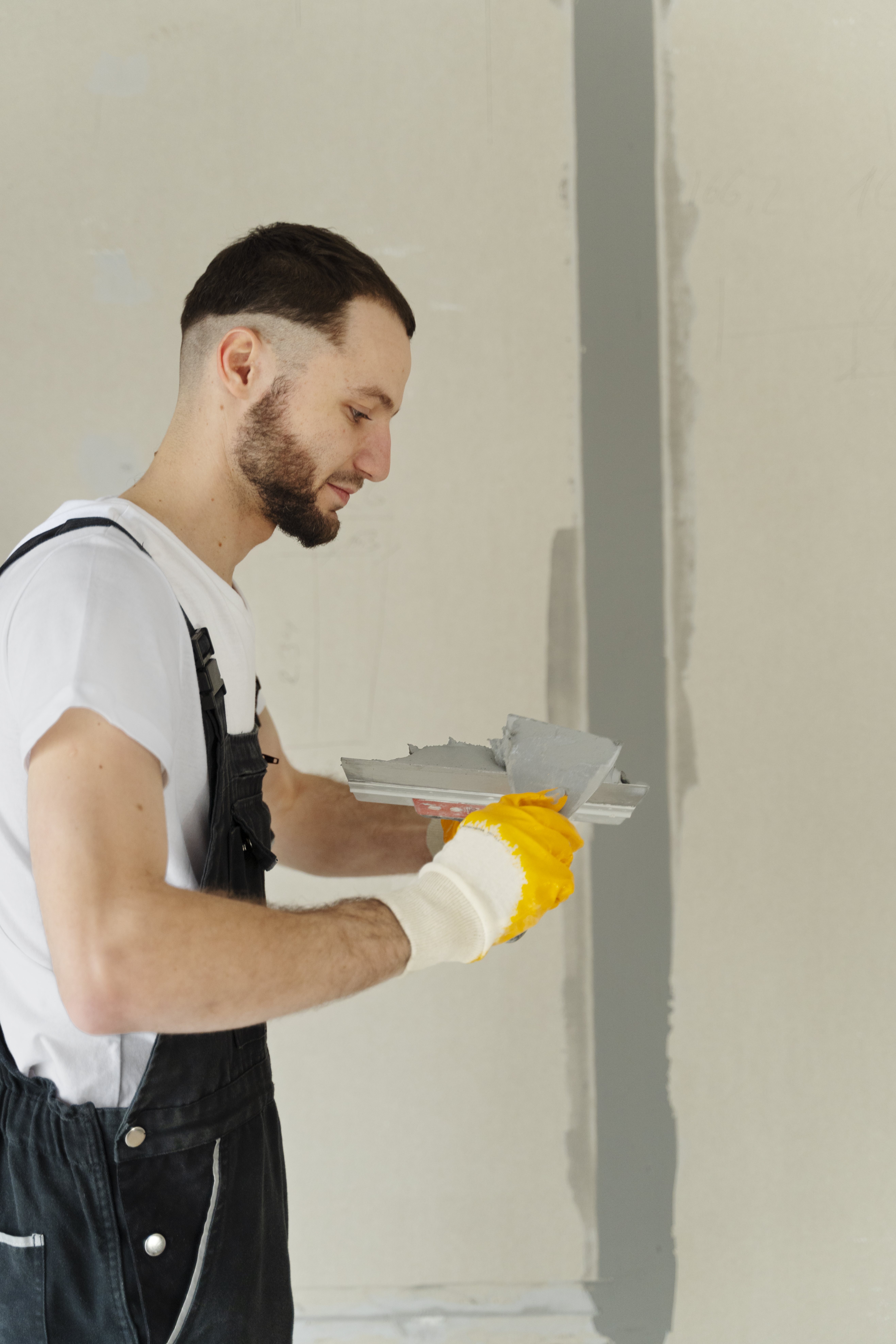 medium shot worker using plastering trowel